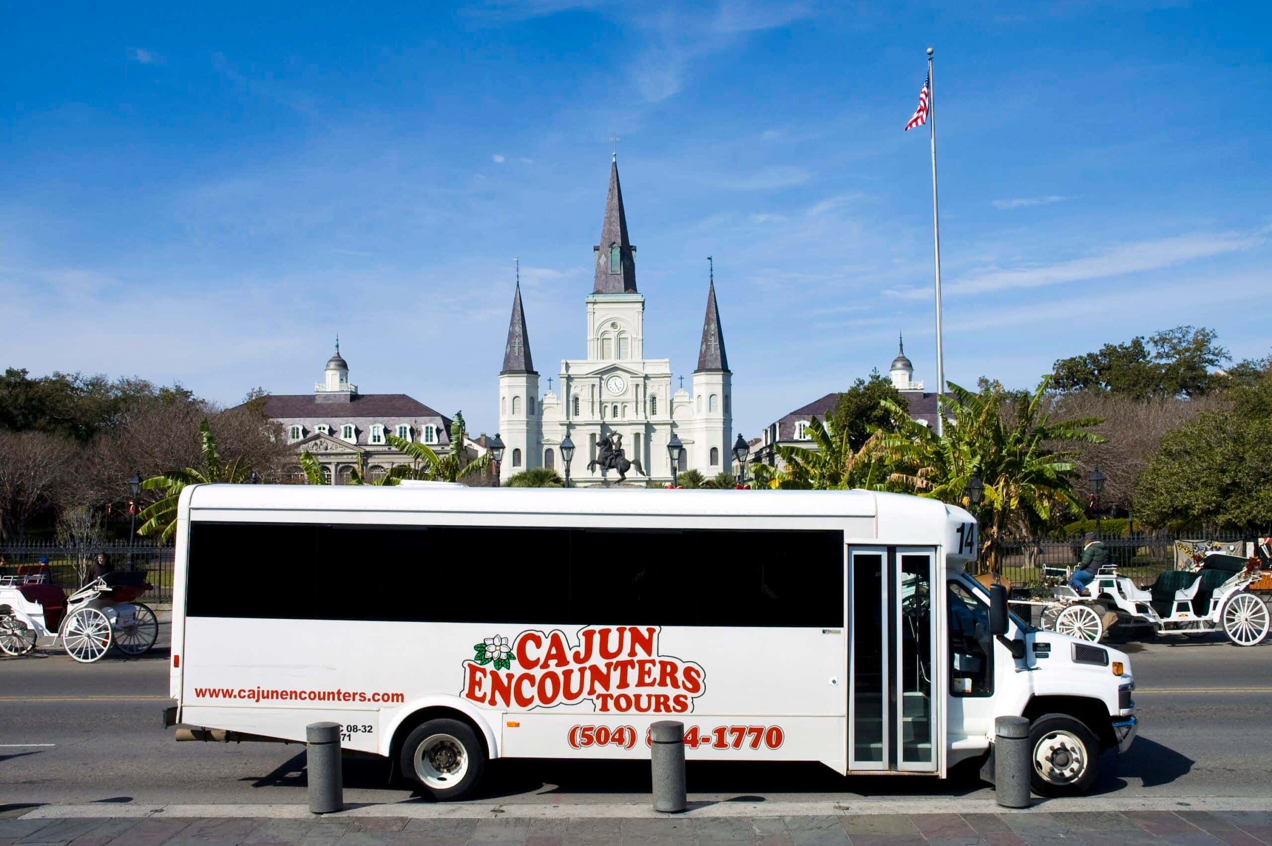 Cajun Encounters city bus tour vehicle parked in front of Jackson Square in New Orleans