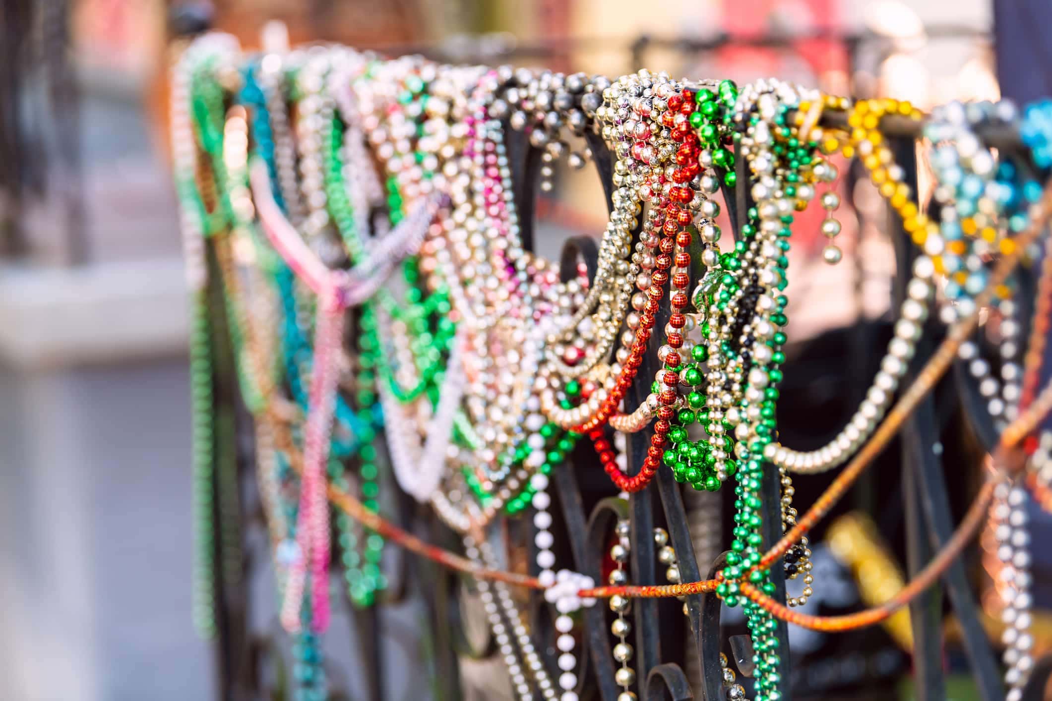 Mardi Gras beads hang from a wrought iron fence in the New Orleans French Quarter