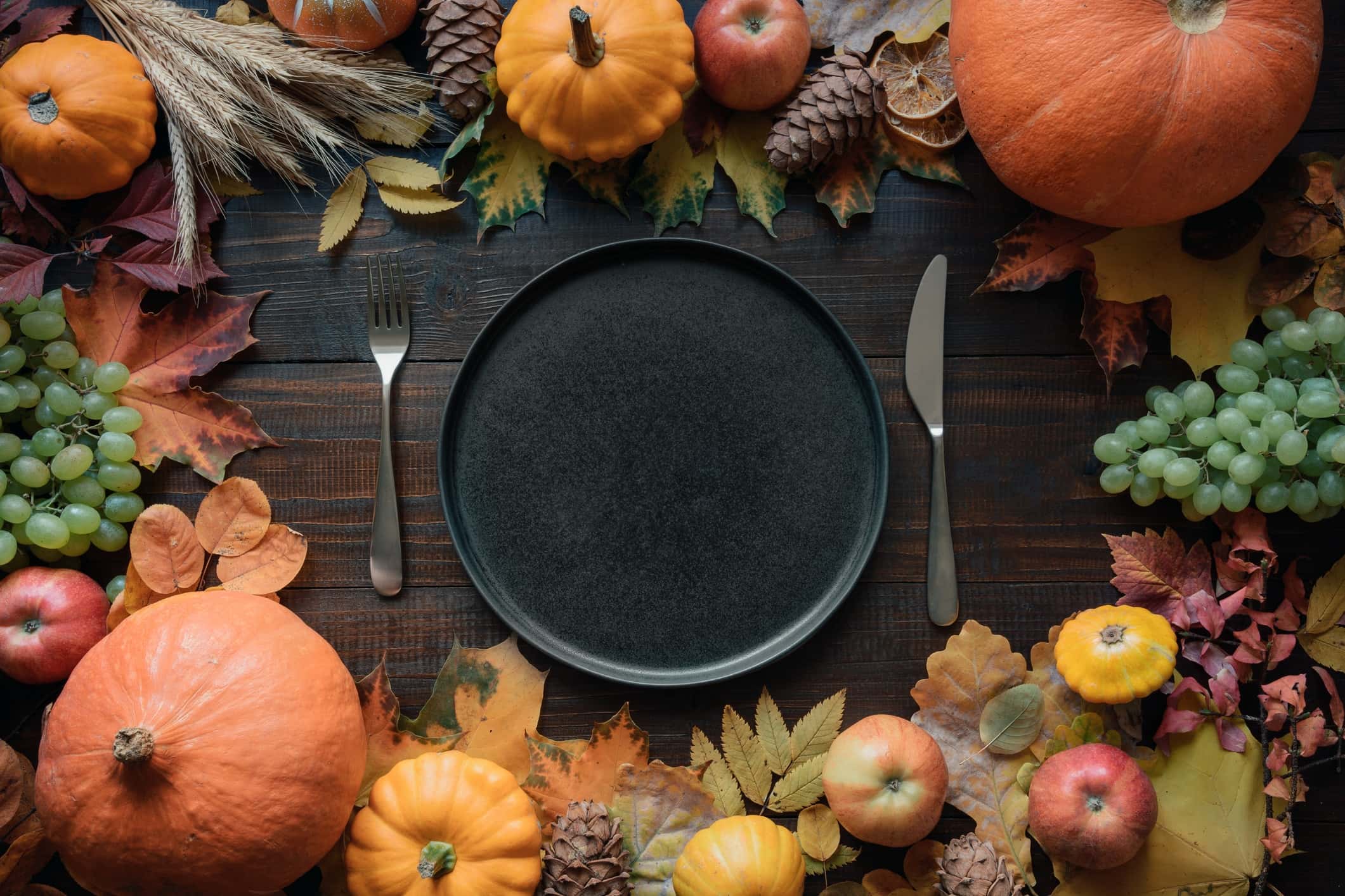 new orleans thanksgiving empty plate with pumpkins, apples, and leaves