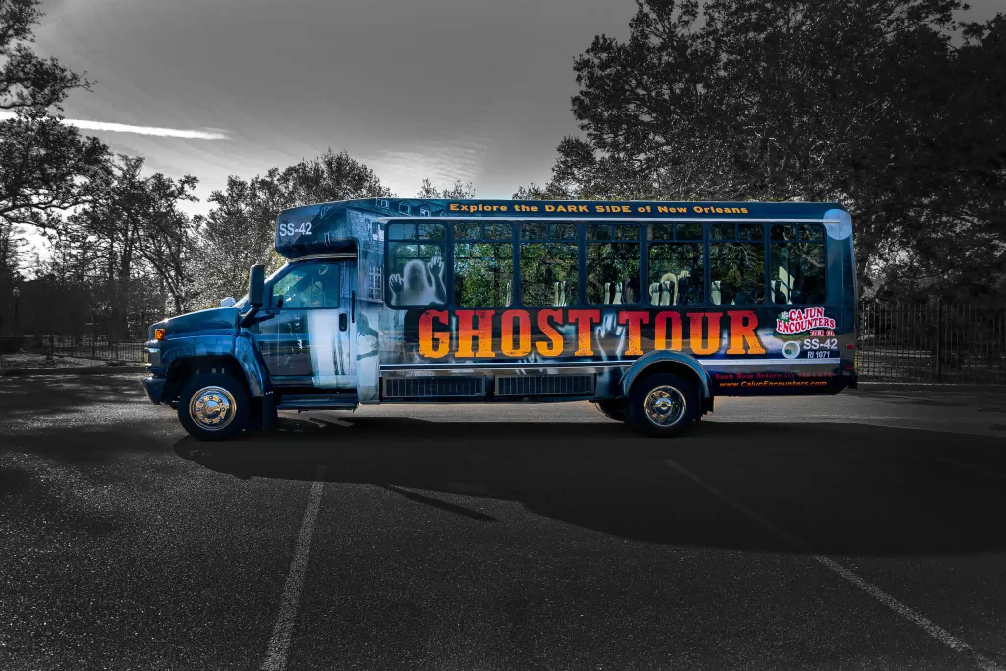 Decorated bus for a cajun encounters ghost tour in New Orleans, featuring eerie graphics and promotional text.