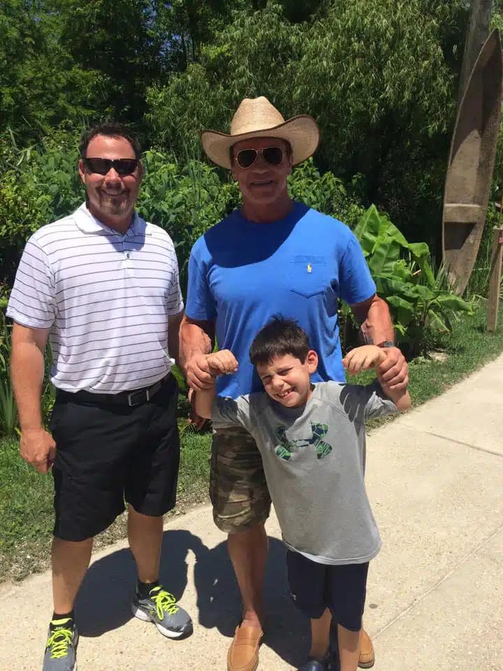 Arnold Schwarzenegger and Jeff Rogers smiling with Arnold's son outside of our swamp tour location