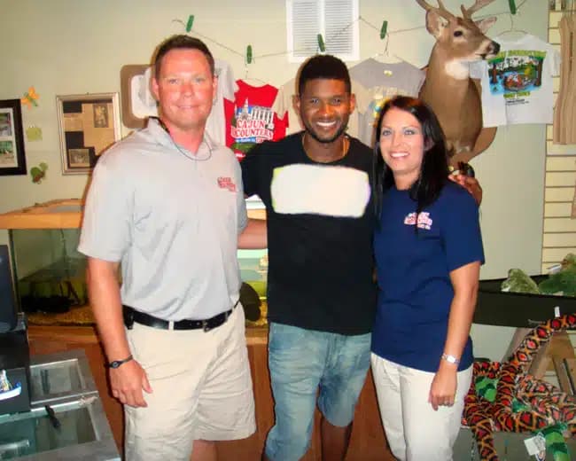 The artist Usher standing with Jeff and Maryanna Rogers in the swamp tour gift shop